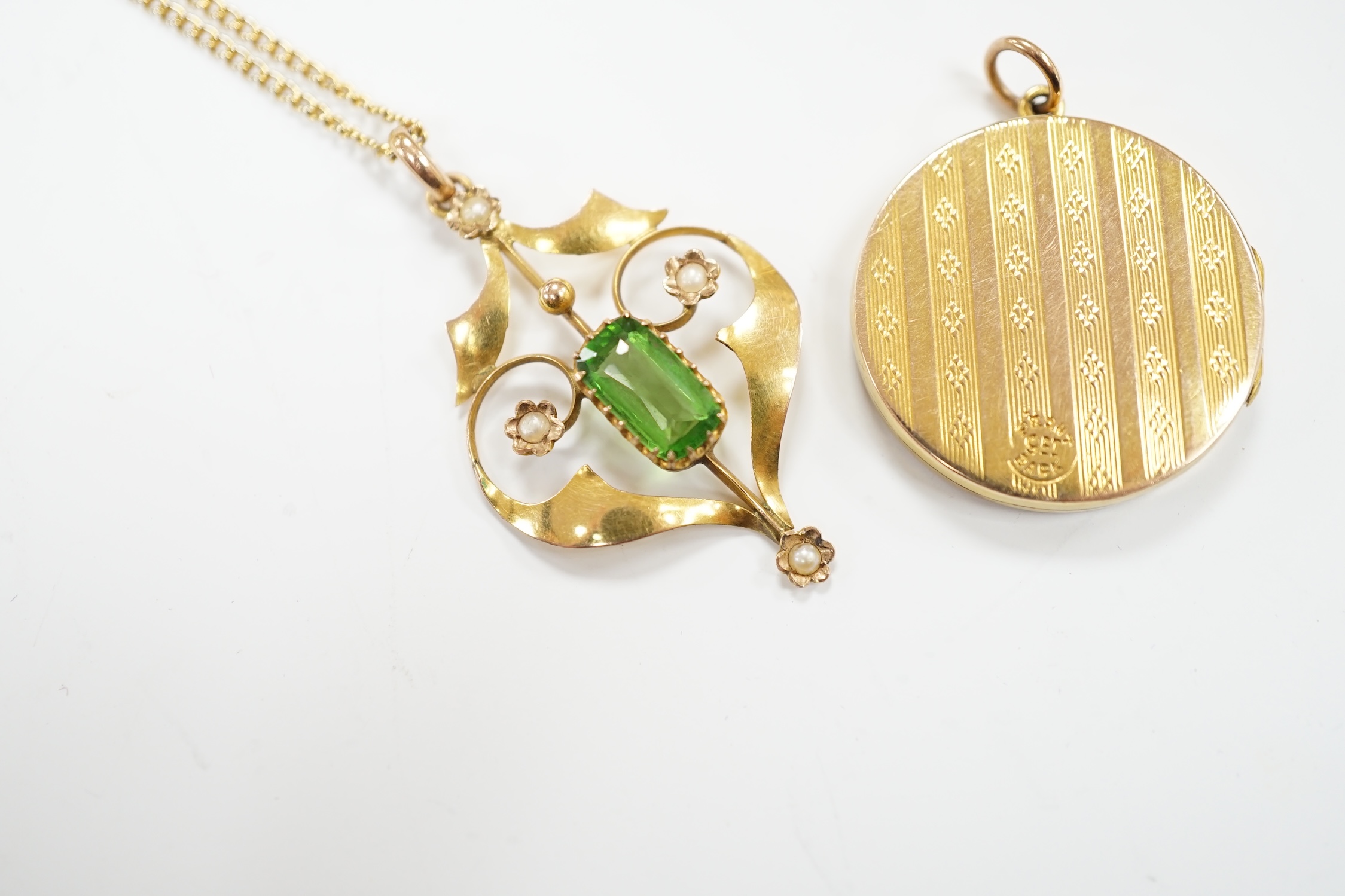 An Edwardian Art Nouveau 9ct, green tourmaline? and seed pearl set pendant, 37mm, on a gilt metal chain, together with a '9ct back and front' locket.